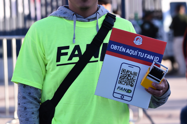 Persona afuera de recinto deportivo promueve la obtención de Fan ID